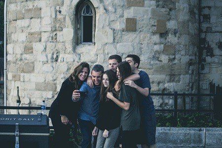 A group of people are posing for a picture in front of a brick building.