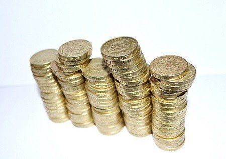 A row of gold coins stacked on top of each other on a white background.