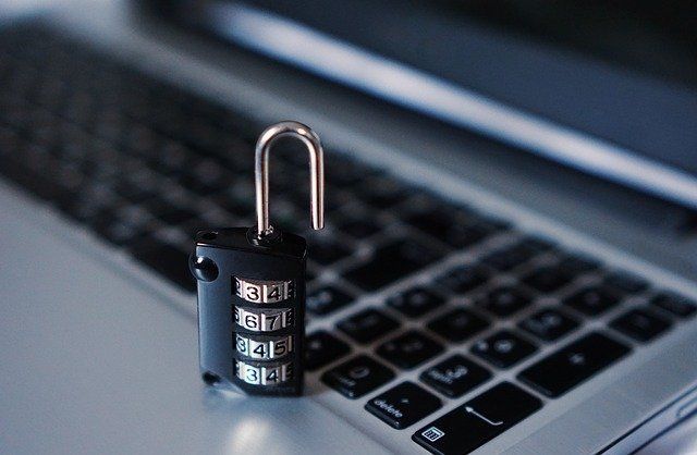 A padlock is sitting on top of a laptop keyboard.