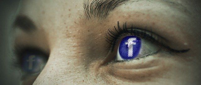 A close up of a woman 's eye with a facebook logo in it.