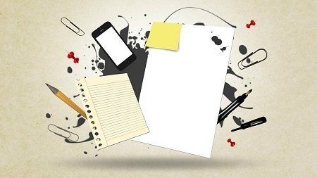 A notebook with a pencil and a cell phone on top of it