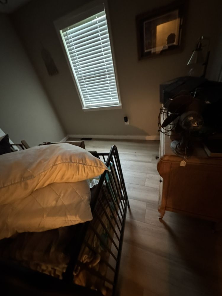 Bedroom with bed, dresser, window with blinds, and slanted ceiling.