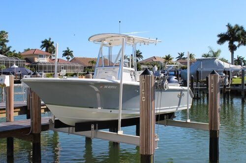 A boat is docked at a dock in the water boat lift repair surf city nc