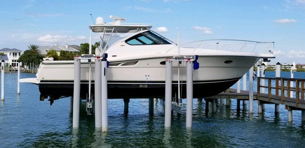 A boat is sitting on a lift in the water. Boat lift parts replacement surf city nc.