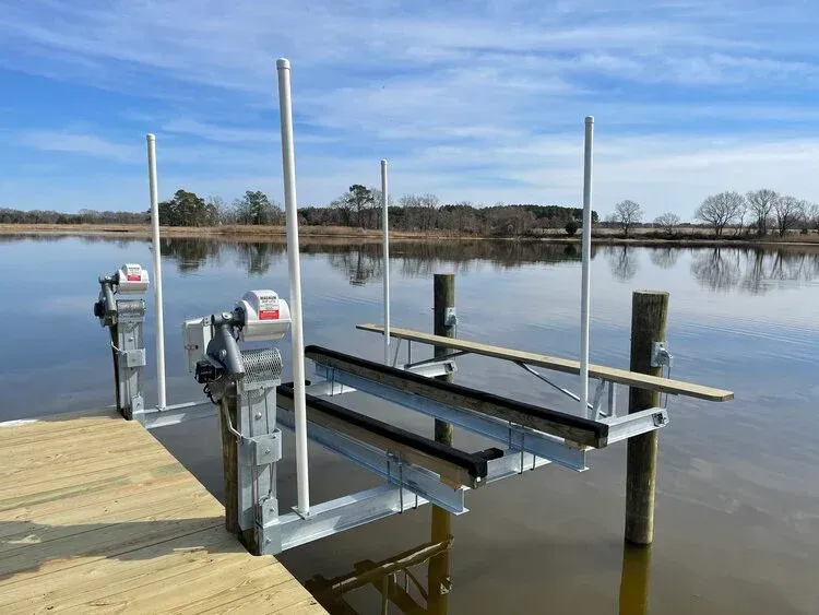 A boat lift is sitting on top of a boat lift next to a body of water in surf city nc