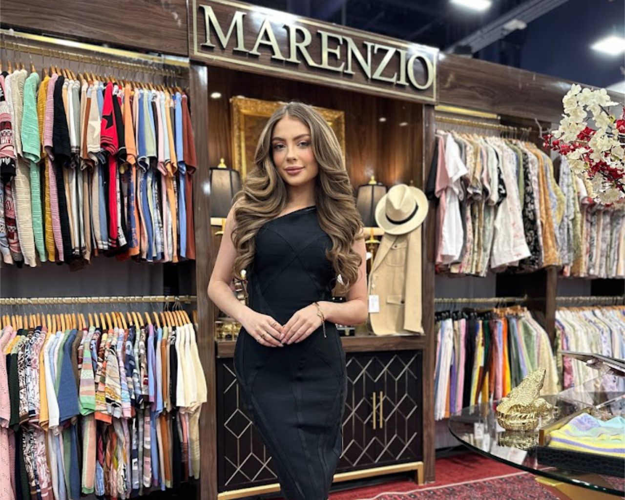 Convention model stands in front of clothing rack display for Marenzio booth at MAGIC convention.