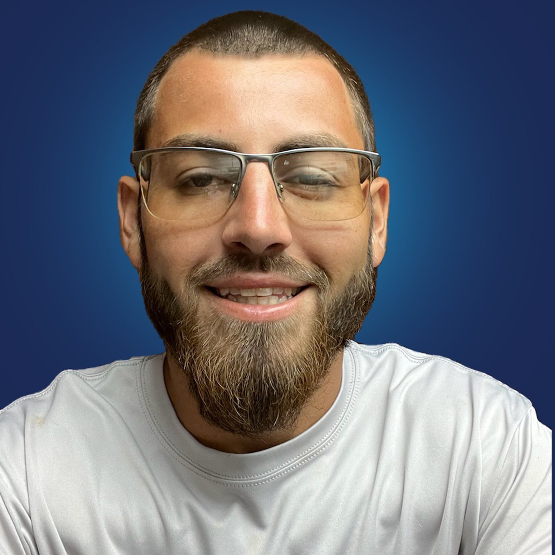 A man with a beard wearing glasses and a white shirt