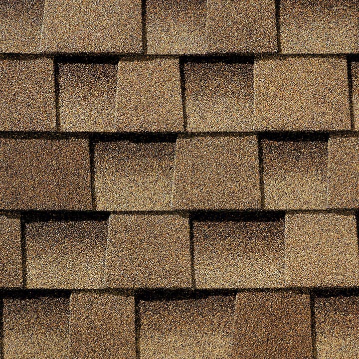 A close up of a roof with brown shingles