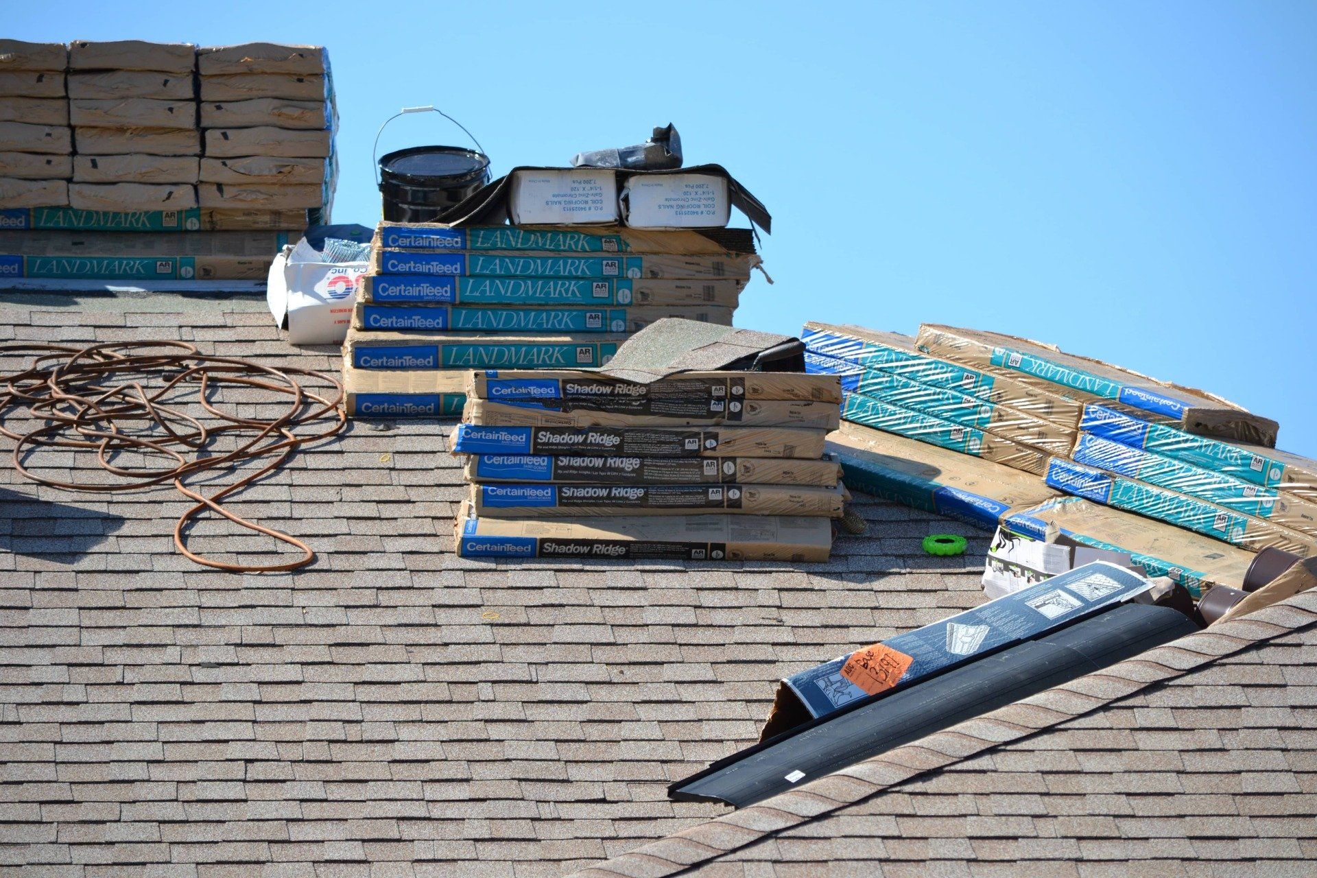 A stack of shingles is sitting on top of a roof.