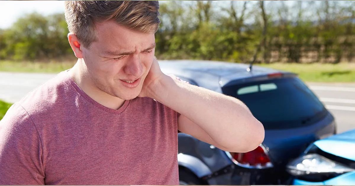 A man is holding his neck in pain after a car accident.