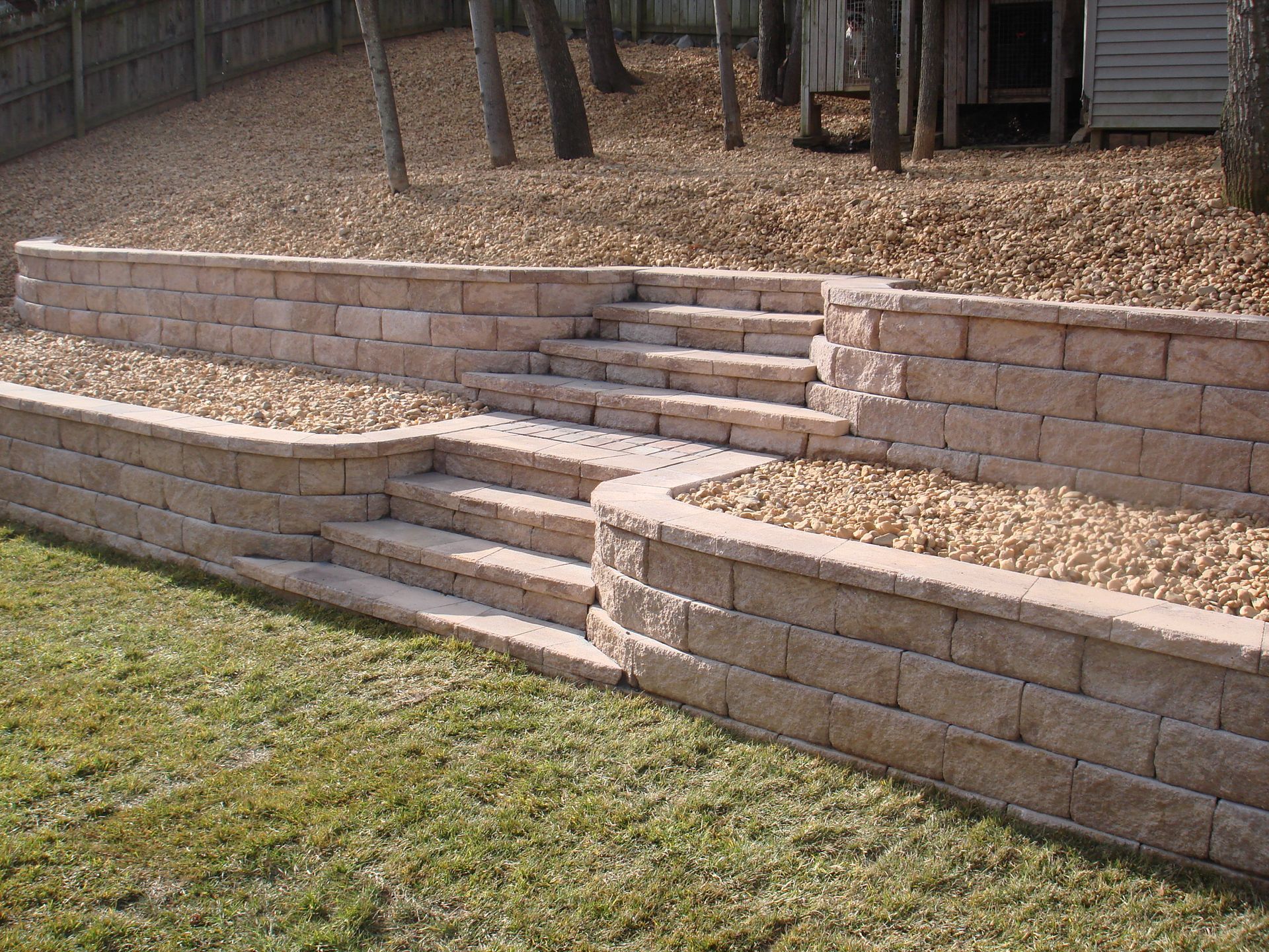 A stone wall with stairs leading up to a house