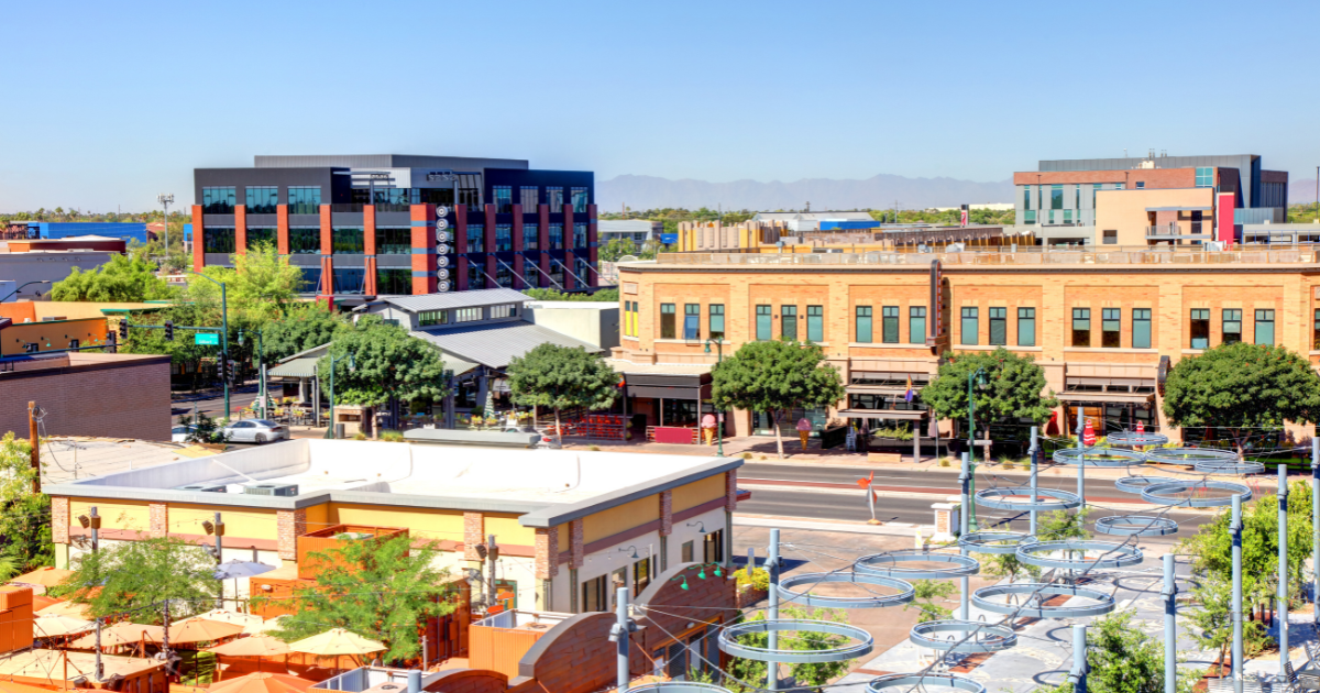 Downtown buildings under a clear blue sky, featuring modern and brick architecture.