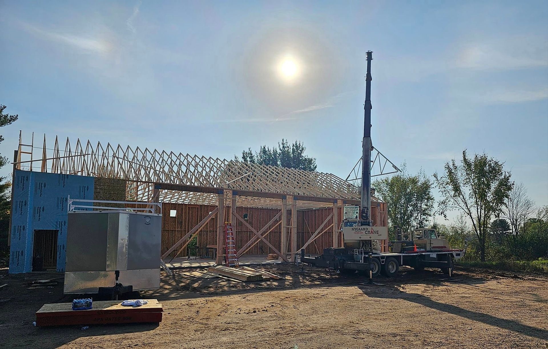 a house is being built in a dirt field with a crane in the background .