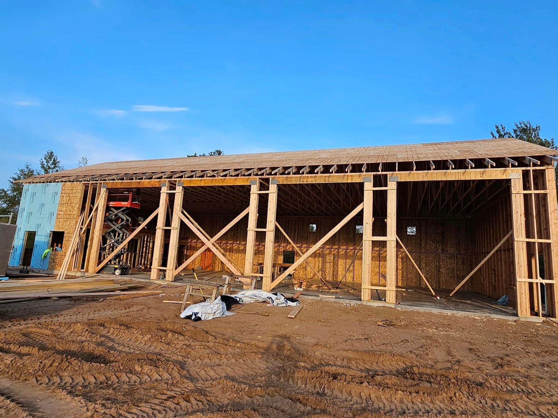 a large wooden structure is being built in a dirt field .