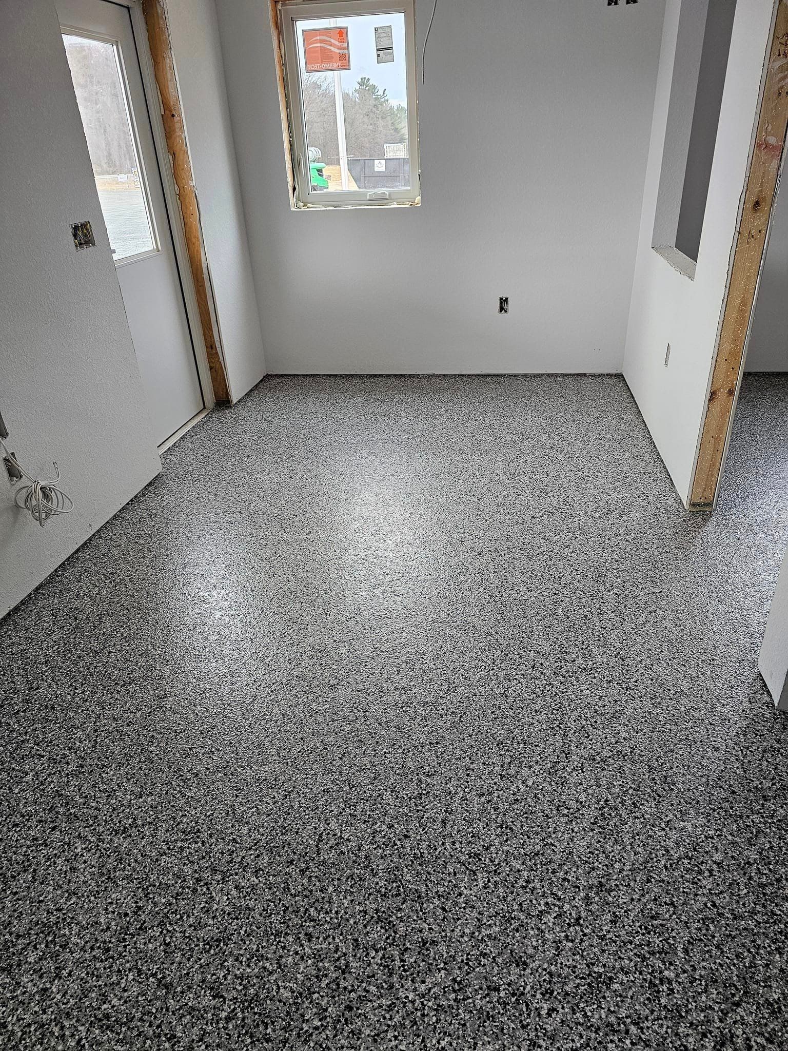 a room with a black and white floor and a window .