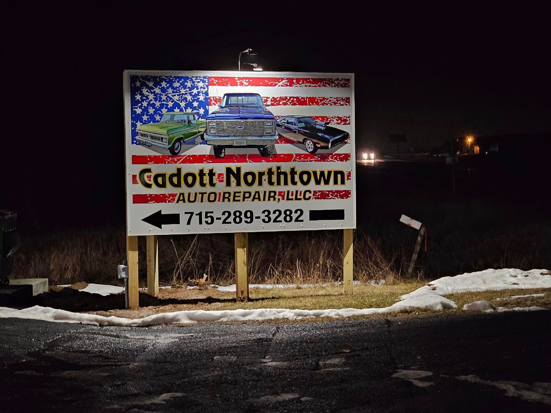 a billboard for cadott northtown auto repair is lit up at night