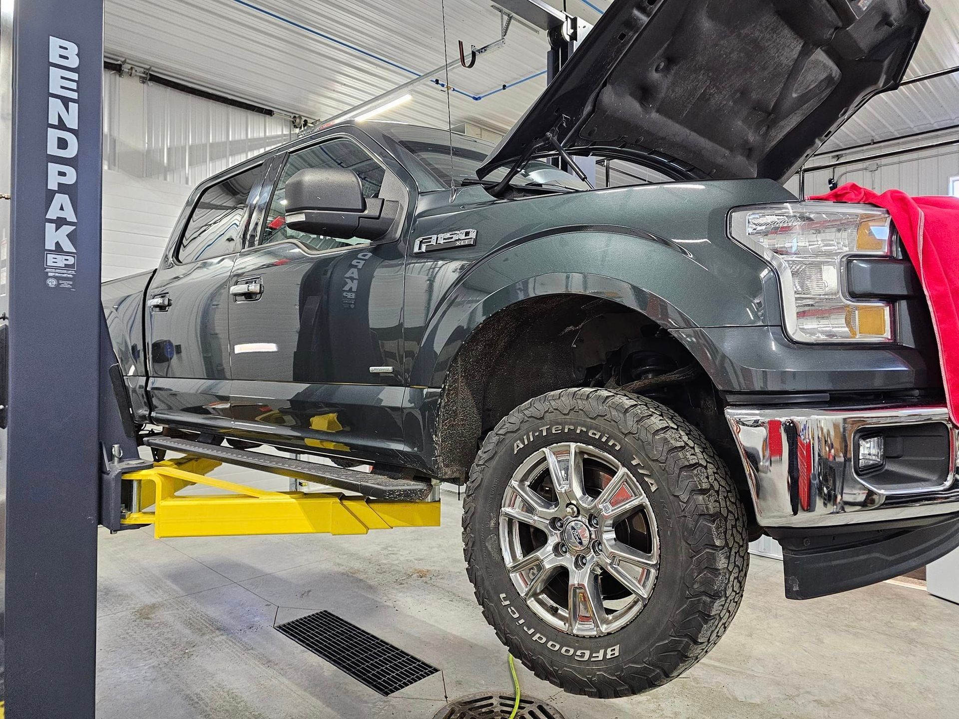 a truck is sitting on a lift with its hood open .