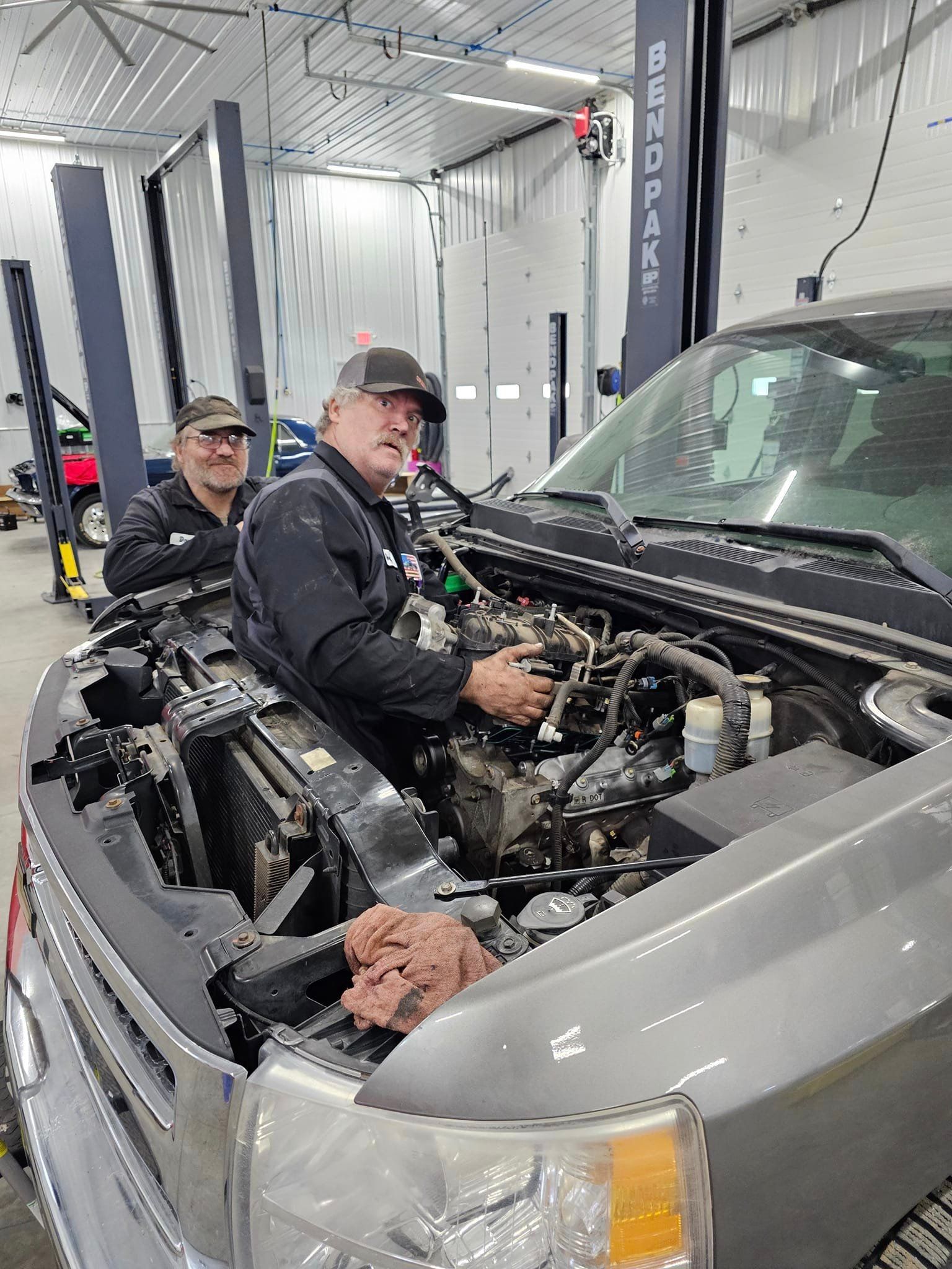 a man is working on the engine of a truck in a garage .