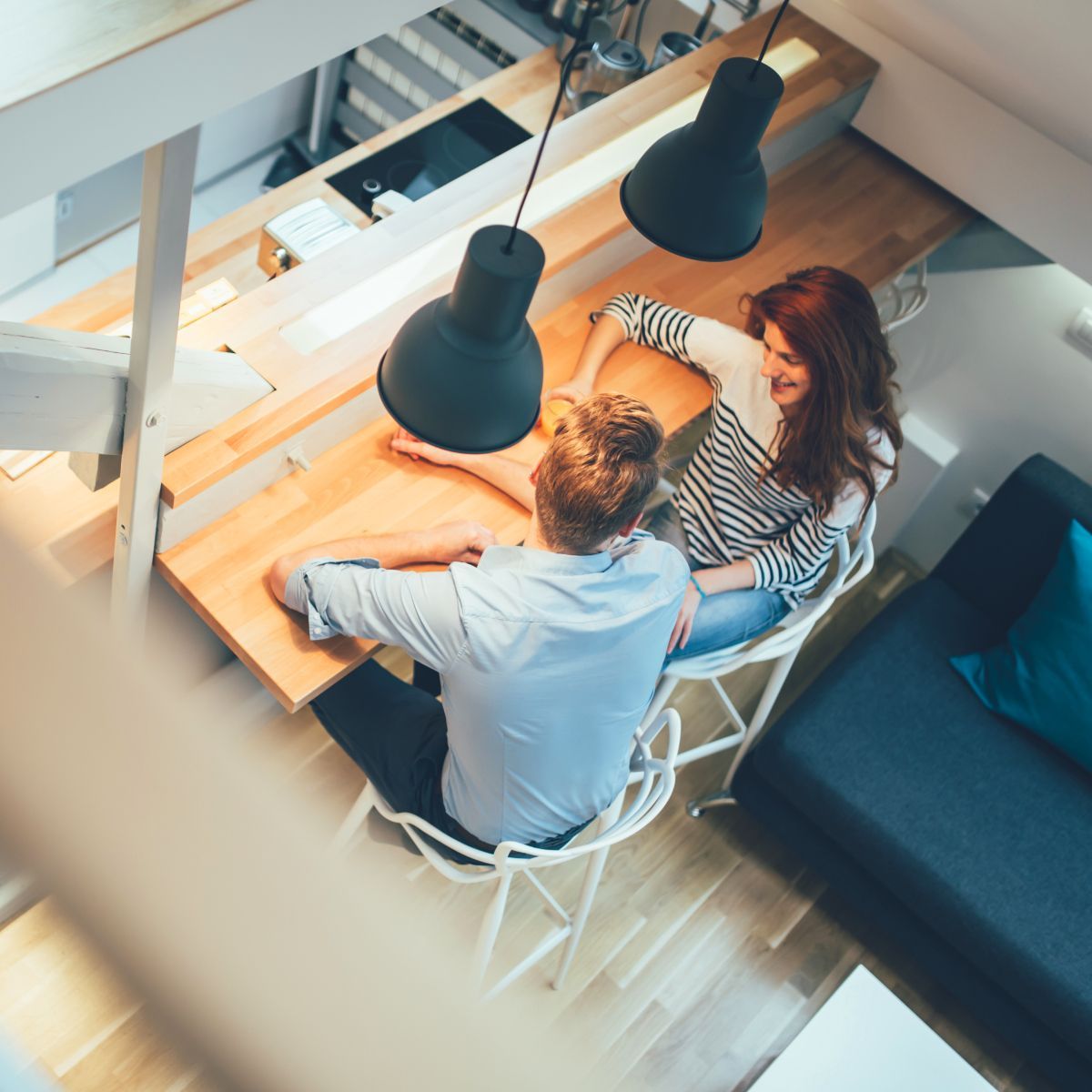 A man and a woman are sitting at a table in a living room