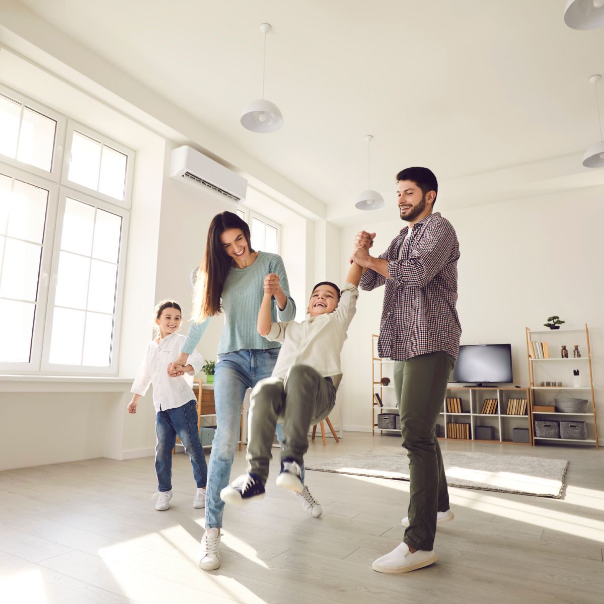 A family is dancing together in a living room.