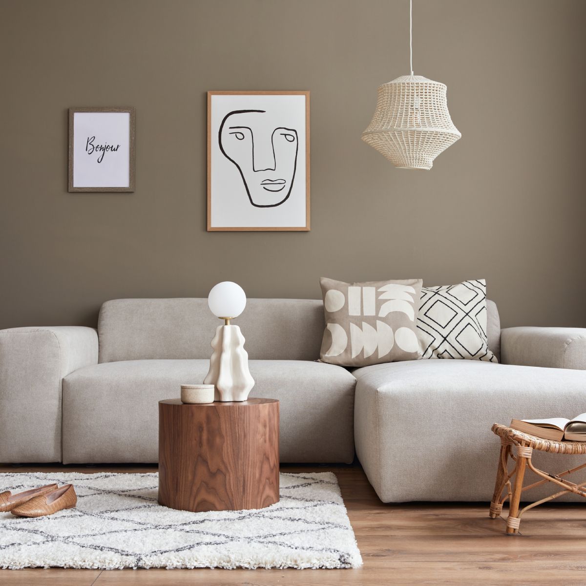 A living room with a couch , coffee table , rug and paintings on the wall.