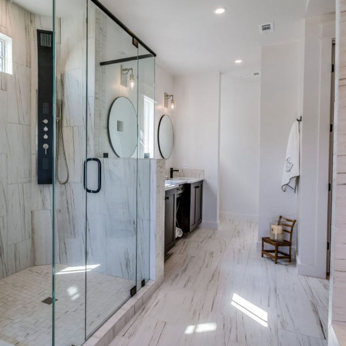 A bathroom with a walk in shower and a sink