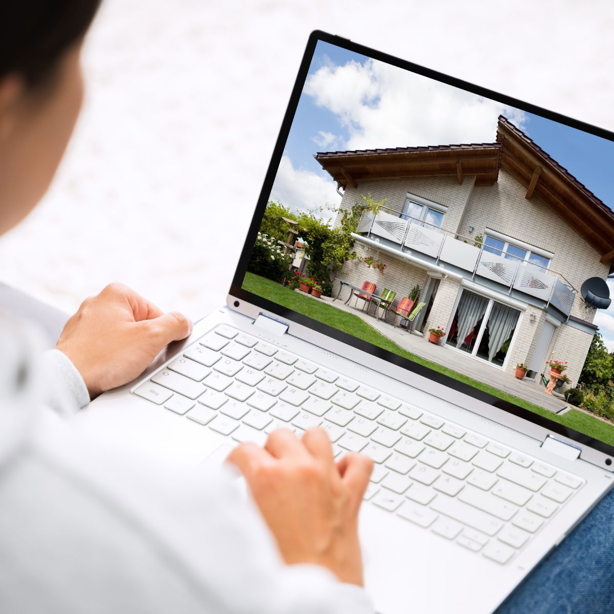 A person is using a laptop with a picture of a house on the screen.