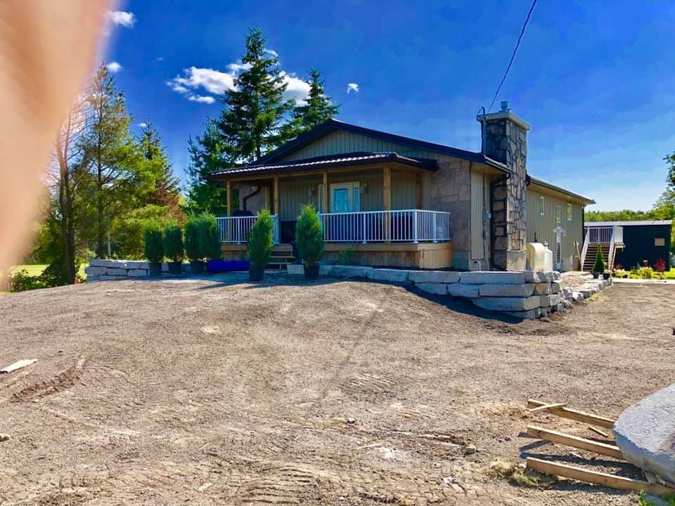 A house is sitting on top of a dirt hill.