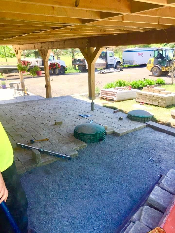 A man is standing on a patio under a canopy.