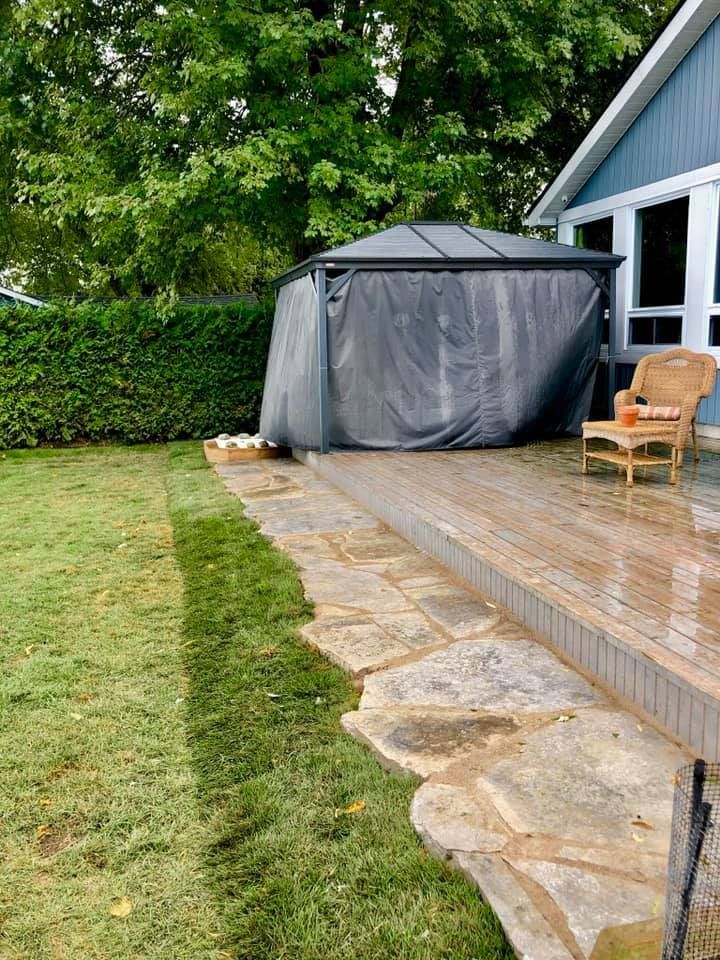 There is a gazebo in the backyard of a house.