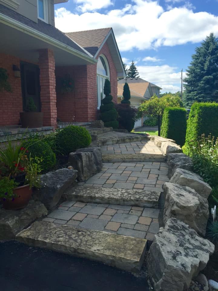 A stone walkway leading to the front of a brick house.