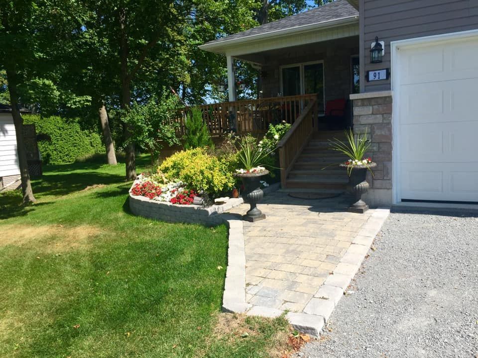 A house with a garage door and a walkway leading to it.