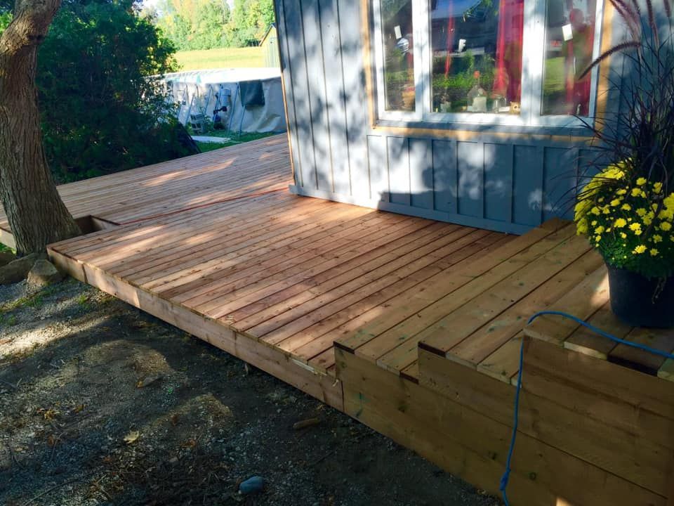 A wooden deck is being built in front of a house.