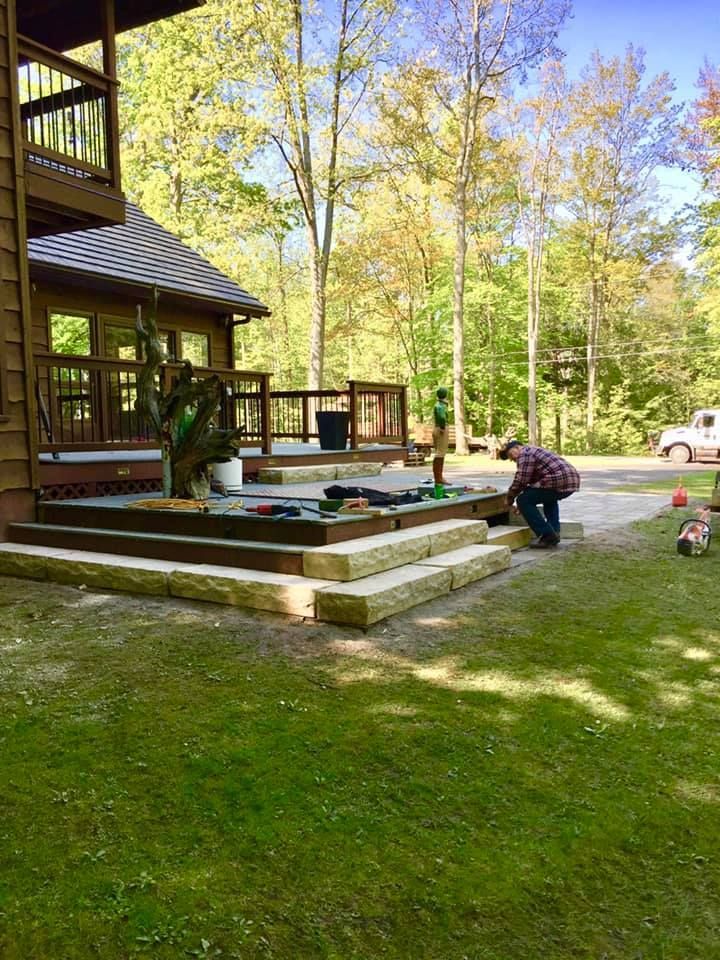 A man is working on a deck in front of a house.