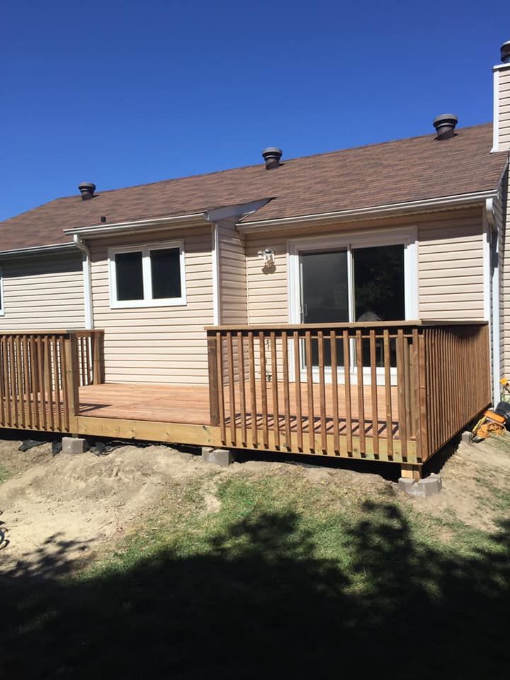A house with a wooden deck in front of it.
