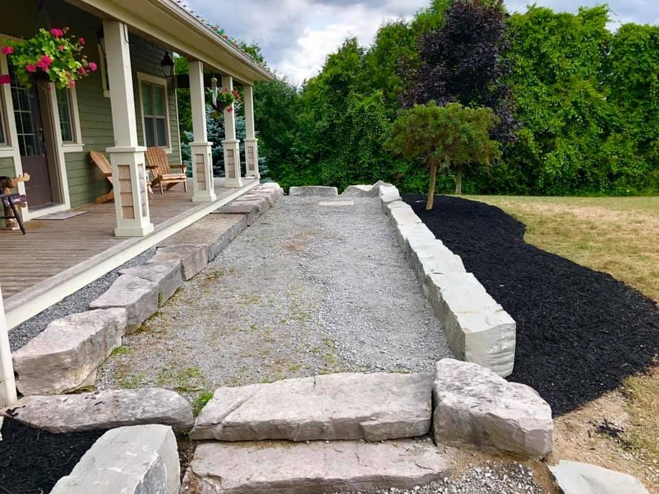 A stone walkway leading to a porch of a house
