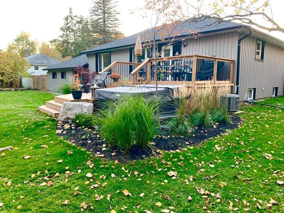 A house with a deck and a hot tub in the backyard.