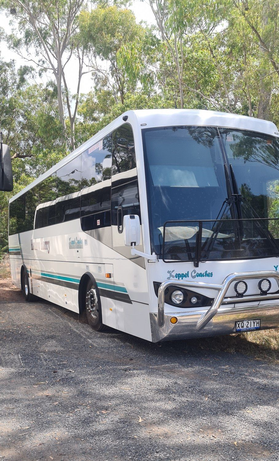 White Coach Bus Parked on a Red Dirt Road Surrounded by Tree — Keppel Coaches in Barmaryee, QLD