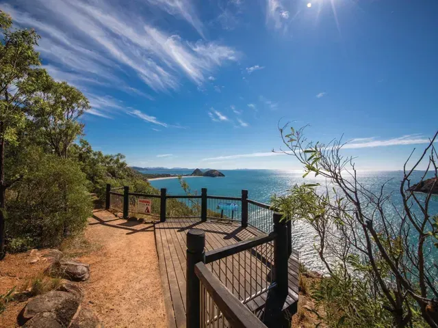 Wooden Viewing Platform Overlooking Blue Ocean, Sandy Beach, and Bright Sun — Keppel Coaches in Barmaryee, QLD
