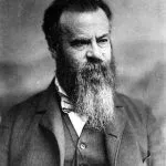 Bearded man in a suit, looking toward the viewer.