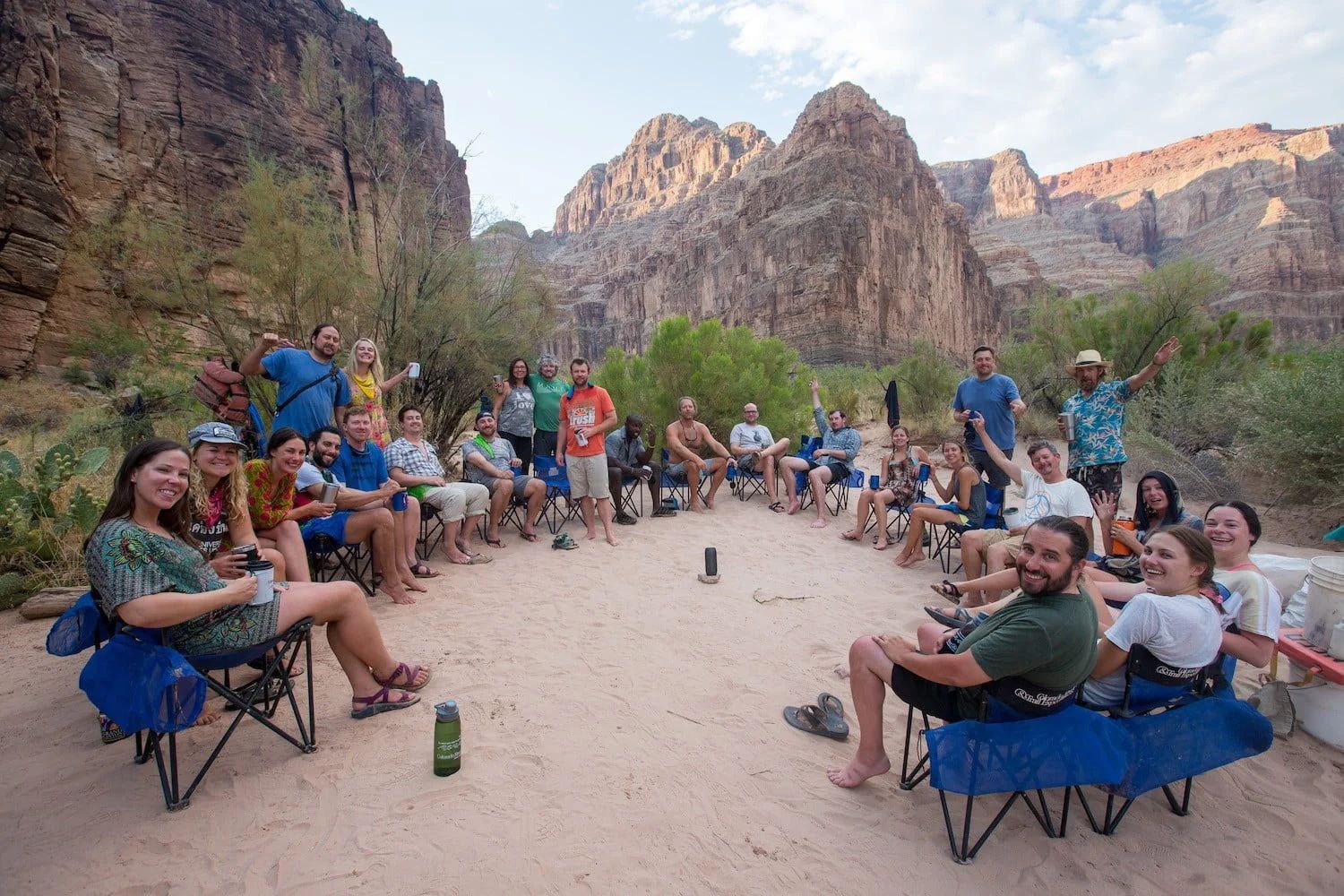Group of people in chairs circle, in a canyon setting.