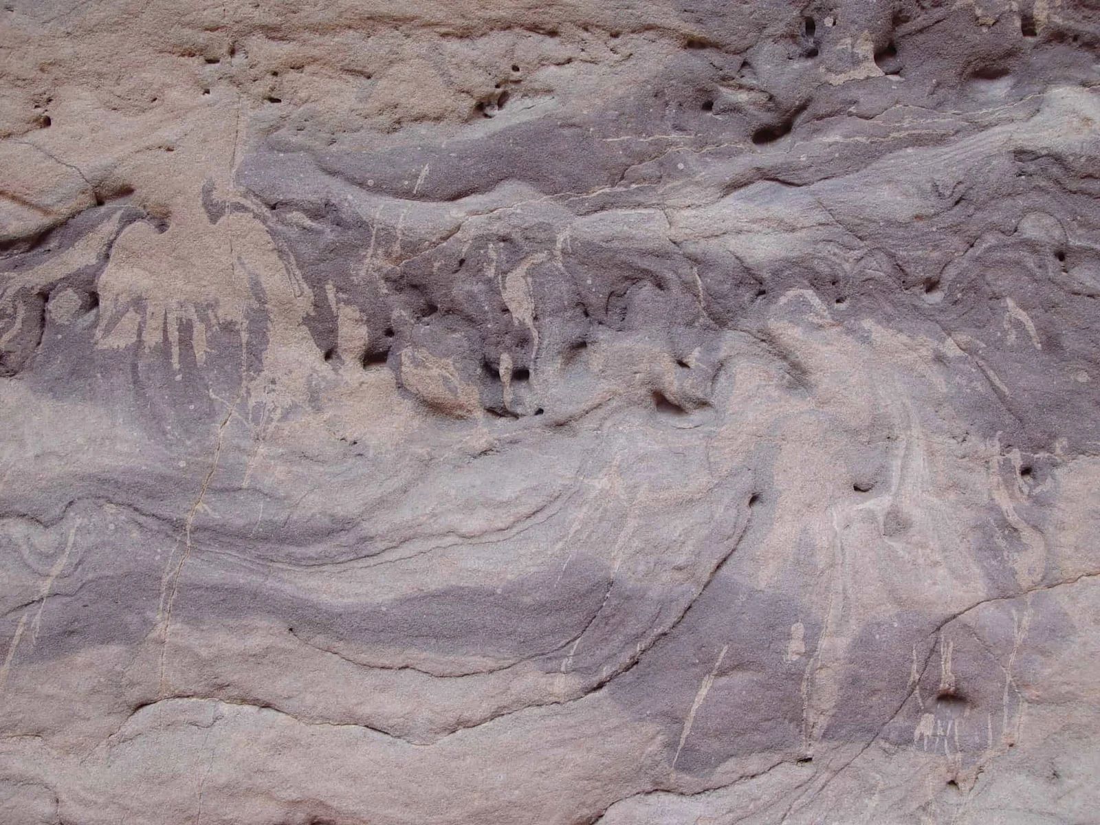 Swirled layers of tan and purple rock formation.