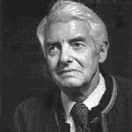 Portrait of a man with white hair, wearing a suit and tie, looking forward with a neutral expression.