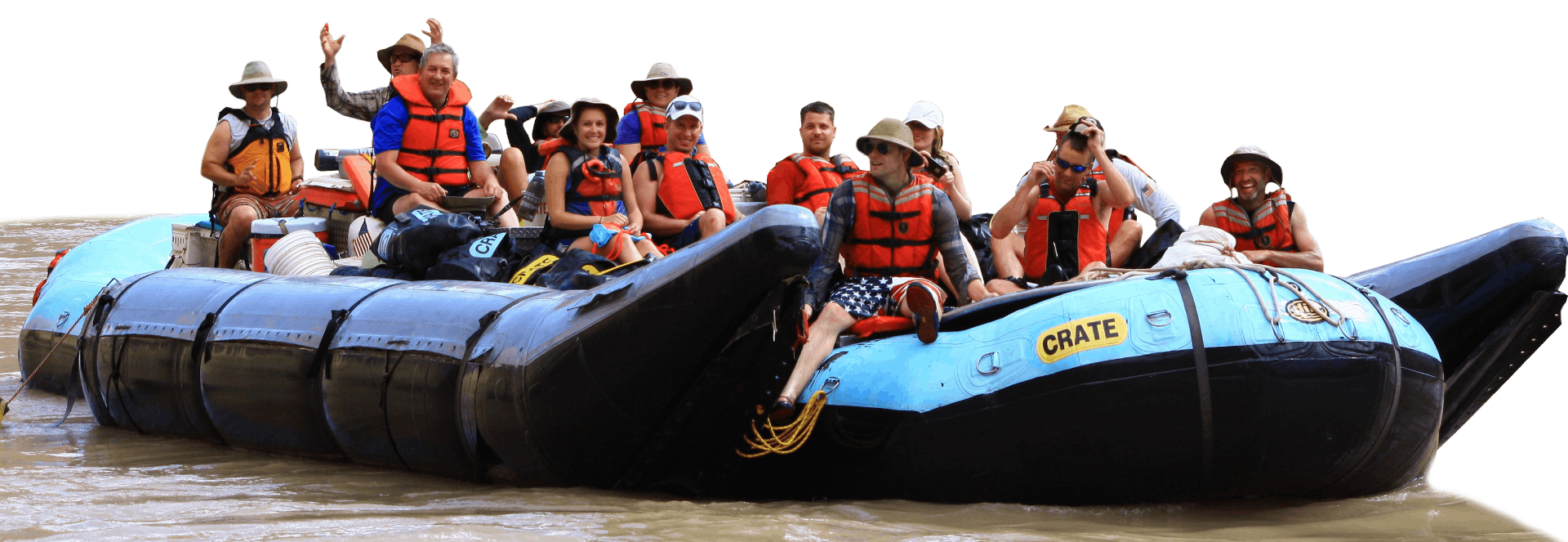 Family in life vests on a raft in the water, waving to the camera.
