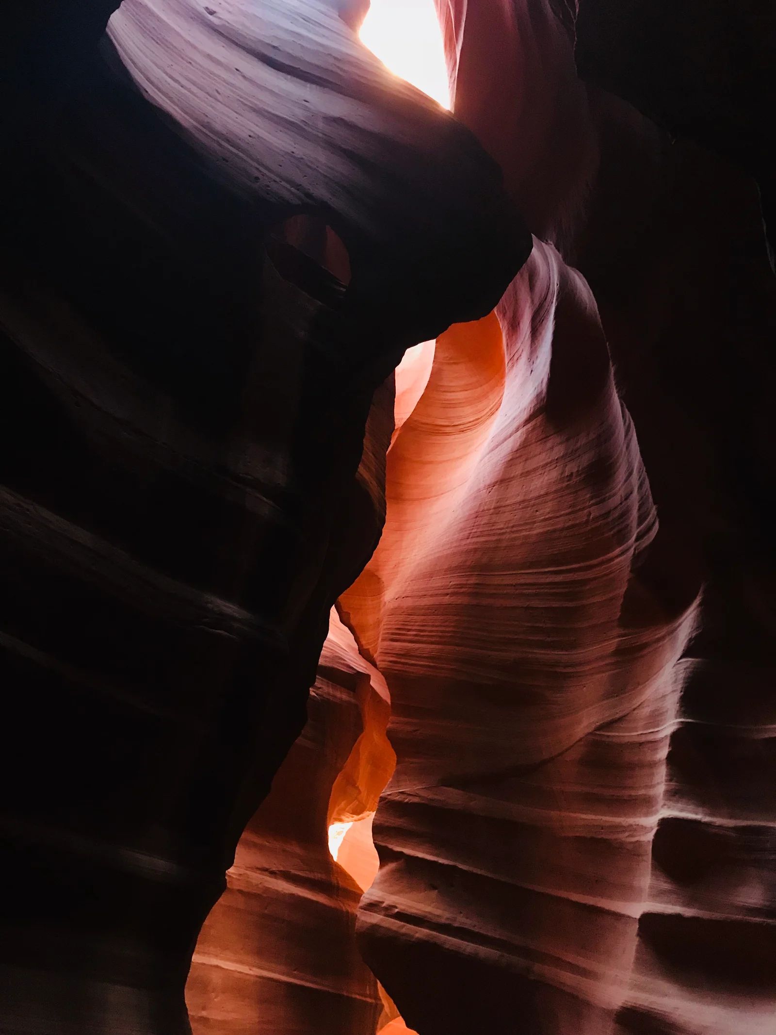 Red and brown sandstone canyon with light streaming from above.