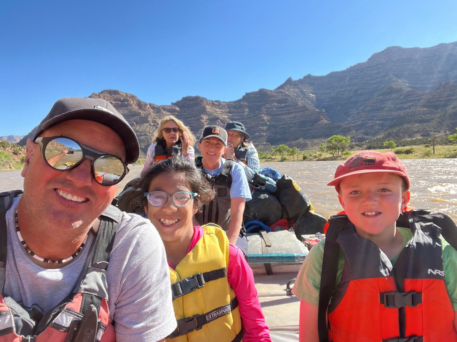 Family on a rafting taking a photo with mountain scenery at the back