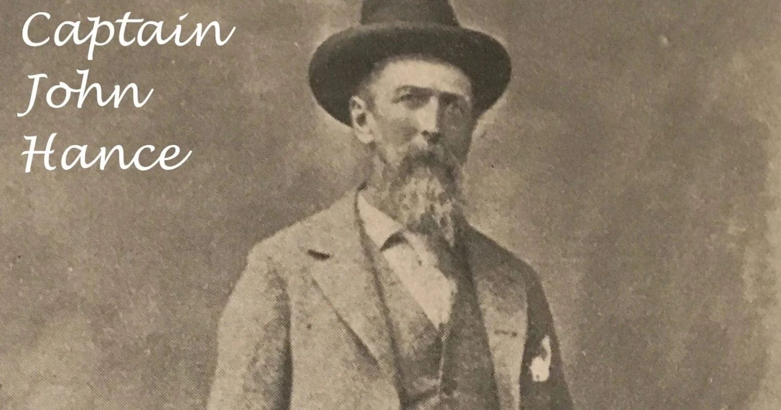 Captain John Hance, graying man with a long beard, wearing a hat and suit.