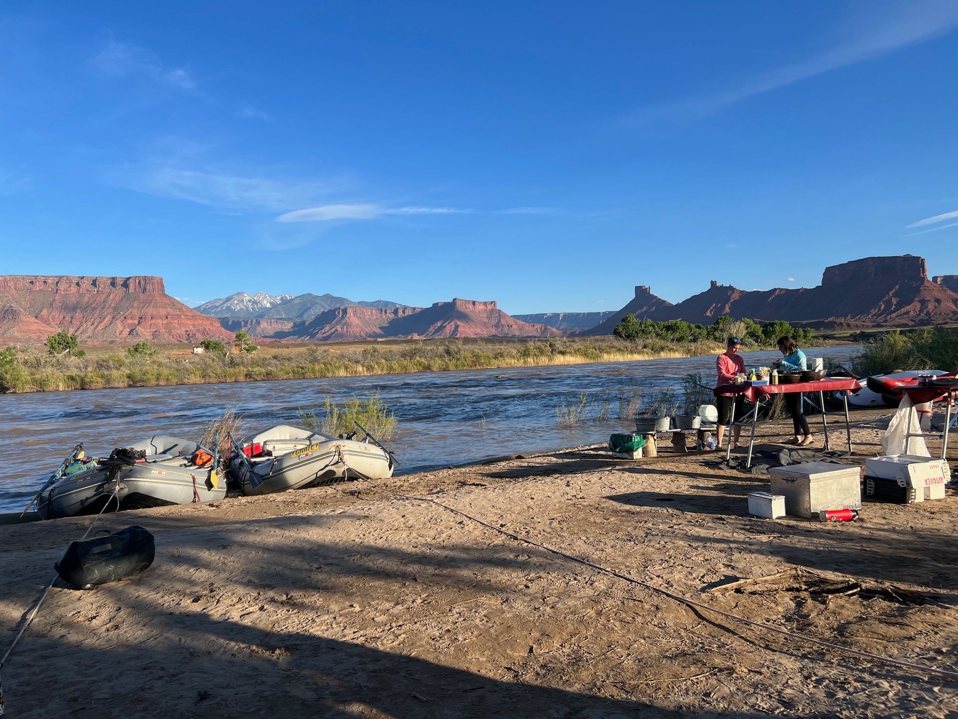 Cataract Canyon River with boats in front of a large rock formation