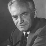 Portrait of a man with gray hair, looking towards the viewer, wearing a suit and tie.