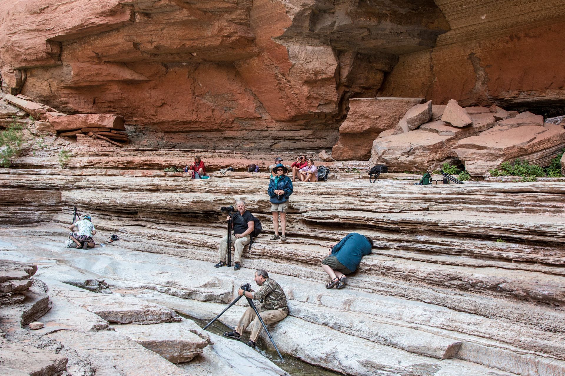 Hikers exploring layered rock formations in a canyon.
